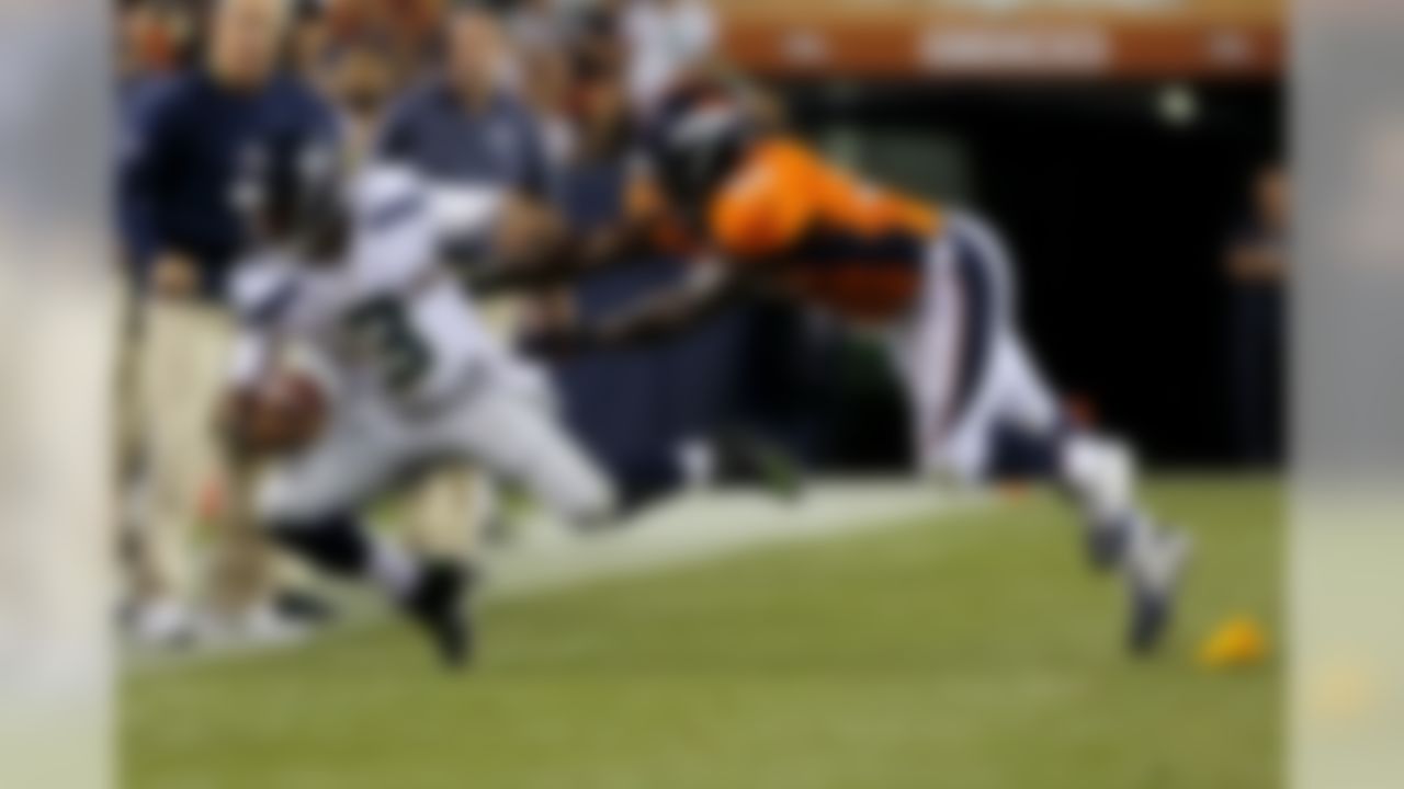 Seattle Seahawks quarterback Russell Wilson (3) is pushed out of bounds by Denver Broncos outside linebacker Nate Irving (56) during the first half of an NFL preseason football game, Thursday, Aug. 7, 2014, in Denver. (AP Photo/Joe Mahoney)