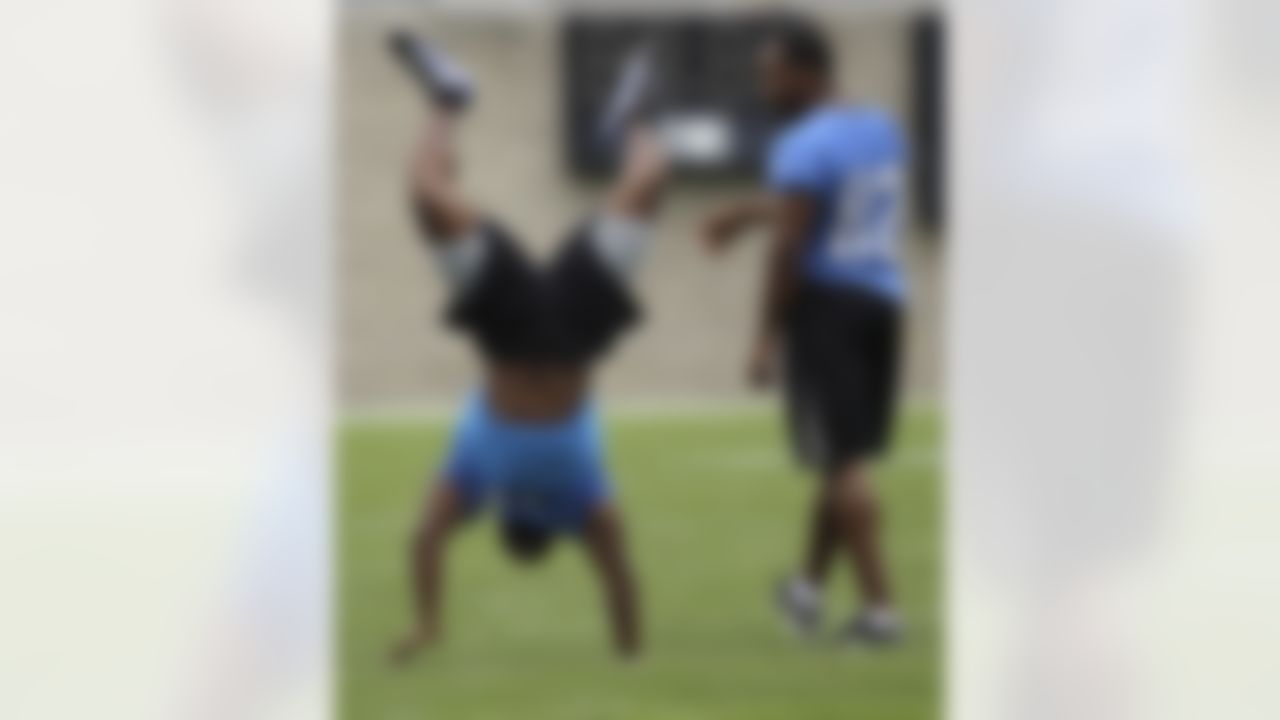 Detroit Lions receiver Rashied Davis (82) watches as teammate Stefan Logan, left, walks on his hands during a break in practice at NFL football training camp in Allen Park, Mich., Tuesday, Aug. 2, 2011. (AP Photo/Carlos Osorio)