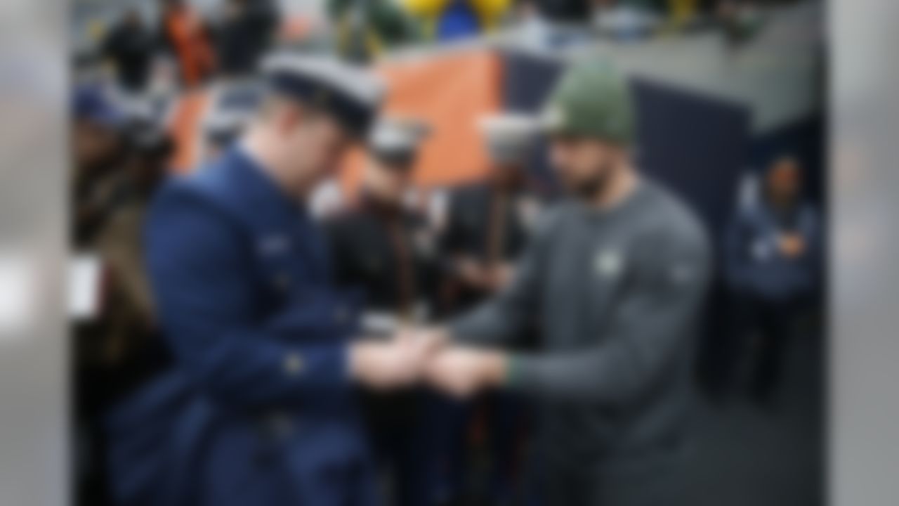 Green Bay Packers' Aaron Rodgers signs autographs for the members of the U.S. Coast Guard and U.S. Marine before an NFL football game against the Chicago Bears, Sunday, Nov. 12, 2017, in Chicago. (AP Photo/Charles Rex Arbogast)