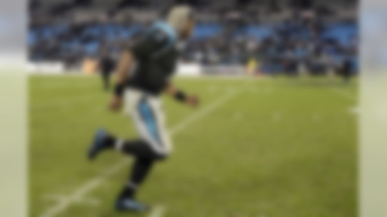 Carolina Panthers quarterback Cam Newton smiles as he runs off the field following Carolina's 24-20 win over the New England Patriots following an NFL football game in Charlotte, N.C., Monday, Nov. 18, 2013. (AP Photo/Gerry Broome)