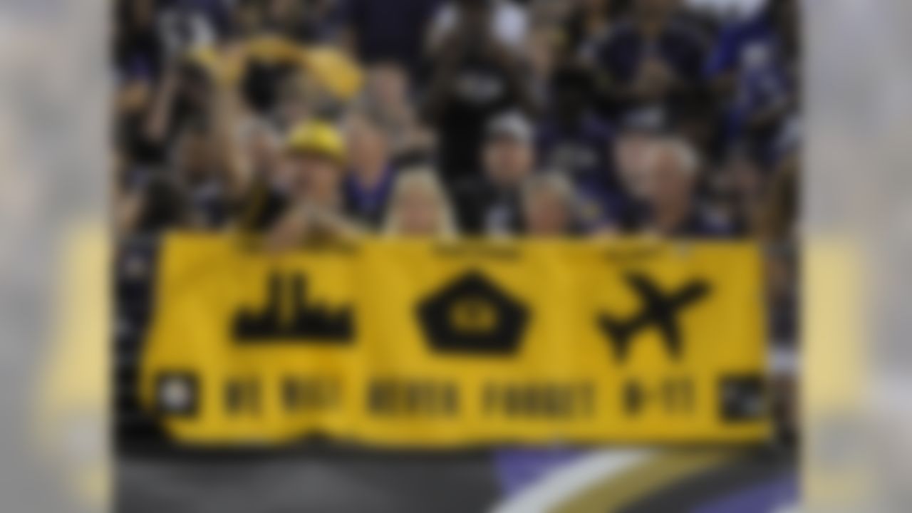 Fans cheer in front of a banner honoring the attacks on 9-11 during the first half of an NFL football game between the Baltimore Ravens and the Pittsburgh Steelers, on Thursday, Sept. 11, 2014, in Baltimore.
