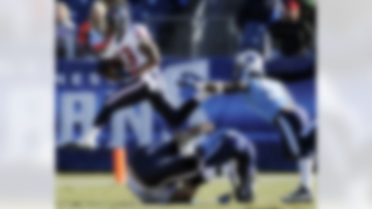 Houston Texans running back Arian Foster (23) leaps over players as he escapes from Tennessee Titans linebacker Stephen Tulloch (55) in the first quarter of an NFL football game on Sunday, Dec. 19, 2010, in Nashville, Tenn. (AP Photo/Joe Howell)