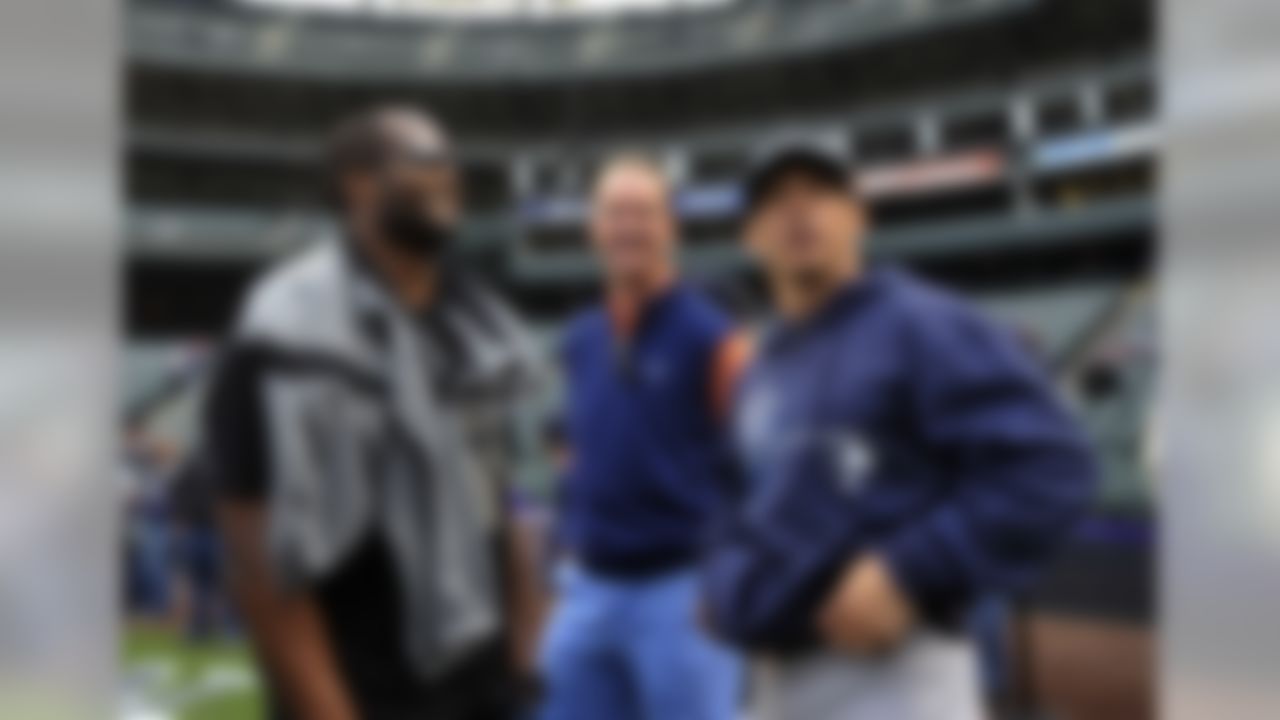 New York Yankees manager Joe Girardi, right, talks with Denver Broncos players  Champ Bailey, left, and Peyton Manning,center,  during batting practice before a baseball game between the New York Yankees and the Colorado Rockies on Tuesday, May 7, 2013, in Denver. (AP Photo/Jack Dempsey)