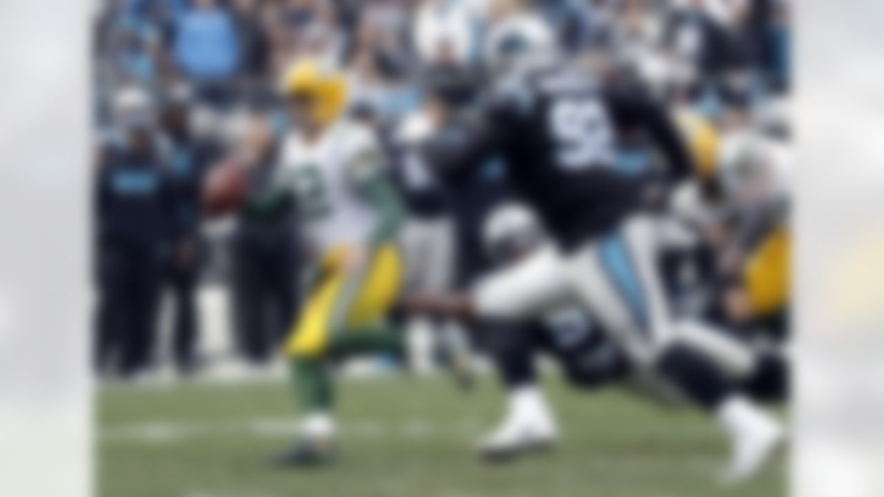 Green Bay Packers' Aaron Rodgers (12) scrambles past Carolina Panthers' Vernon Butler (92) during the first half of an NFL football game in Charlotte, N.C., Sunday, Dec. 17, 2017. (AP Photo/Bob Leverone)