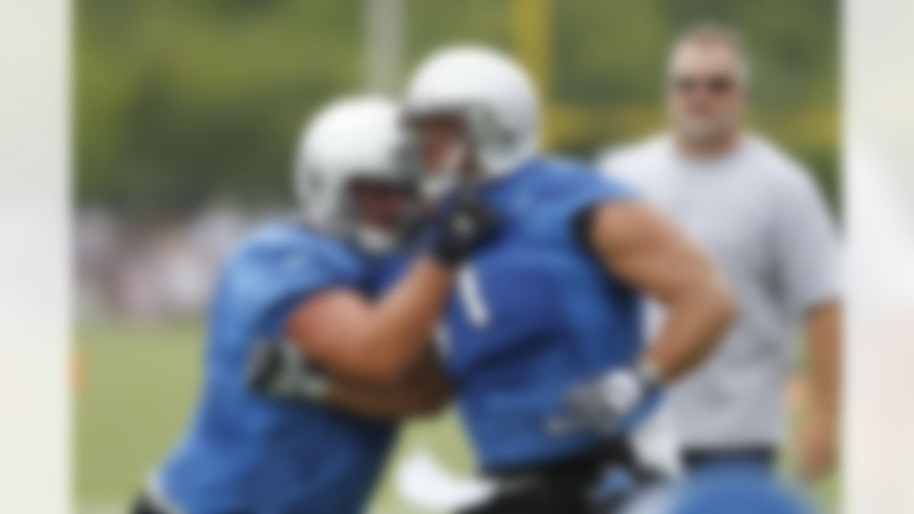 Detroit Lions guard Trevor Canfield, left, pushes back center Dominic Raiola during drills at NFL football training camp in Allen Park, Mich., Saturday, July 31, 2010. (AP Photo/Carlos Osorio)
