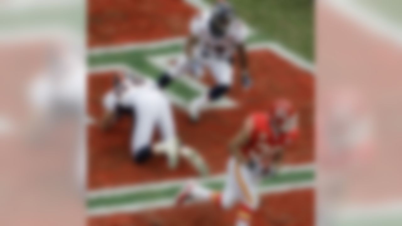 Kansas City Chiefs safety Mike Brown (30) runs from Denver Broncos tight end Tony Scheffler (88) and wide receiver Eddie Royal after intercepting a pass intended for Scheffler during the first quarter of an NFL football game Sunday, Dec. 6, 2009 in Kansas City, Mo. (AP Photo/Charlie Riedel)