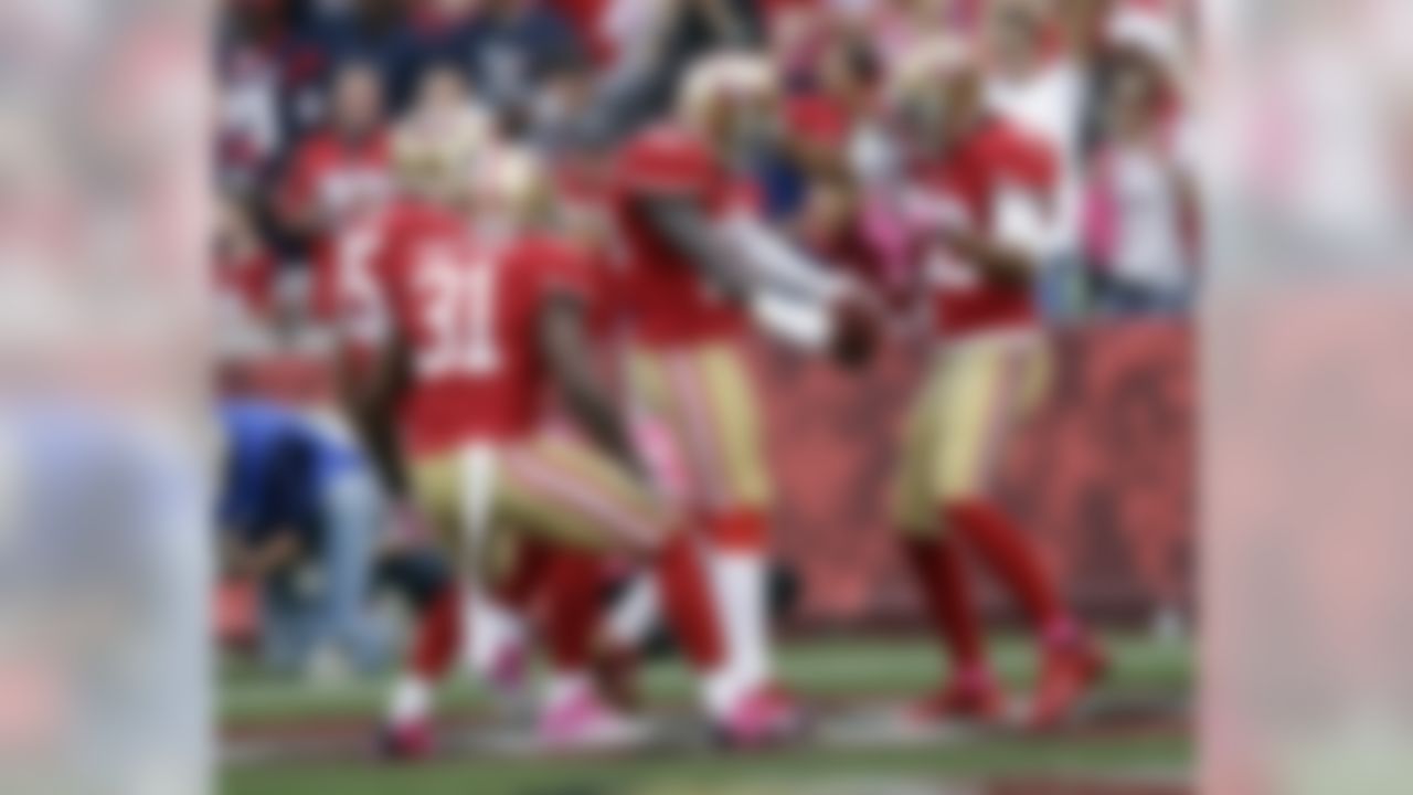 San Francisco 49ers cornerback Tramaine Brock (26) is congratulated by Eric Reid (35), Donte Whitner (31) and Carlos Rogers (22) after scoring a touchdown in the first quarter an NFL football game against the Houston Texans in San Francisco, Sunday, Oct. 6, 2013. (AP Photo/Marcio Jose Sanchez)