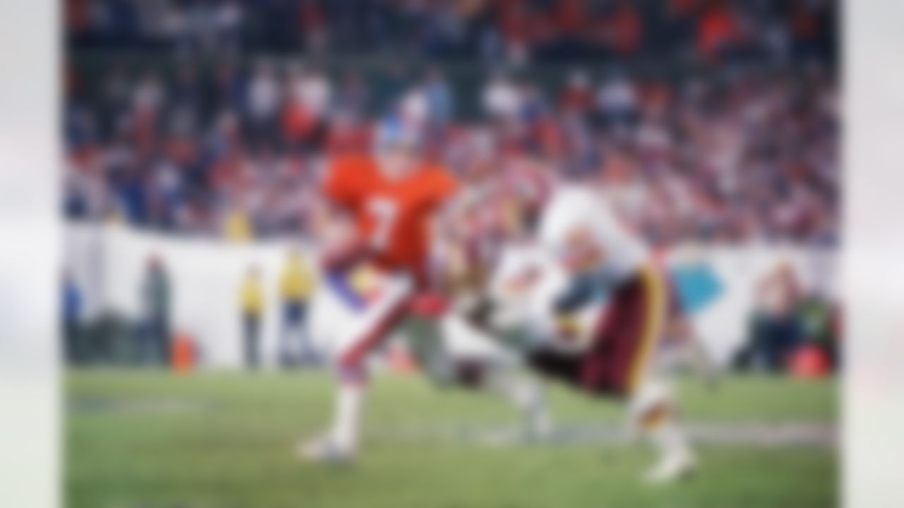 Denver Broncos quarterback John Elway (7) falls under the defense of Washington's Dexter Manley and Monte Coleman (51) during Sunday's Super Bowl XXII at Jack Murphy Stadium, February 1, 1988 in San Diego, CA. (Associated Press)