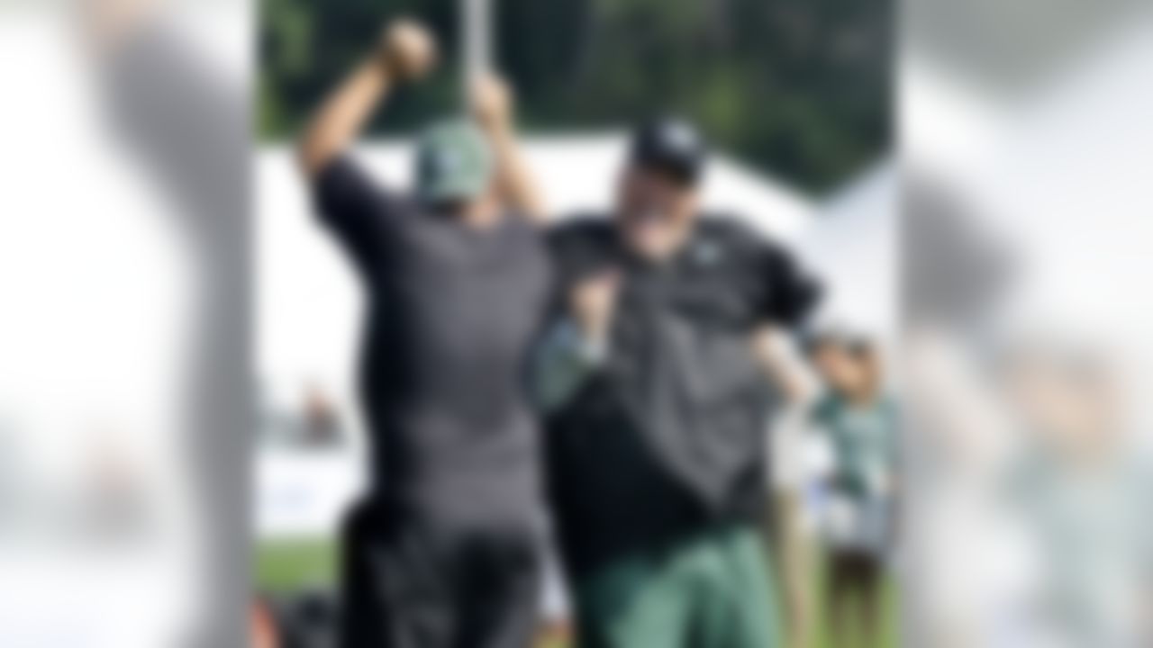 New York Jets head coach Rex Ryan, right, bumps outside linebacker coach Jeff Weeks while having some fun during morning practice at the team's NFL football training camp in Cortland, N.Y., Wednesday, Aug. 4, 2010. (AP Photo/Kevin Rivoli)