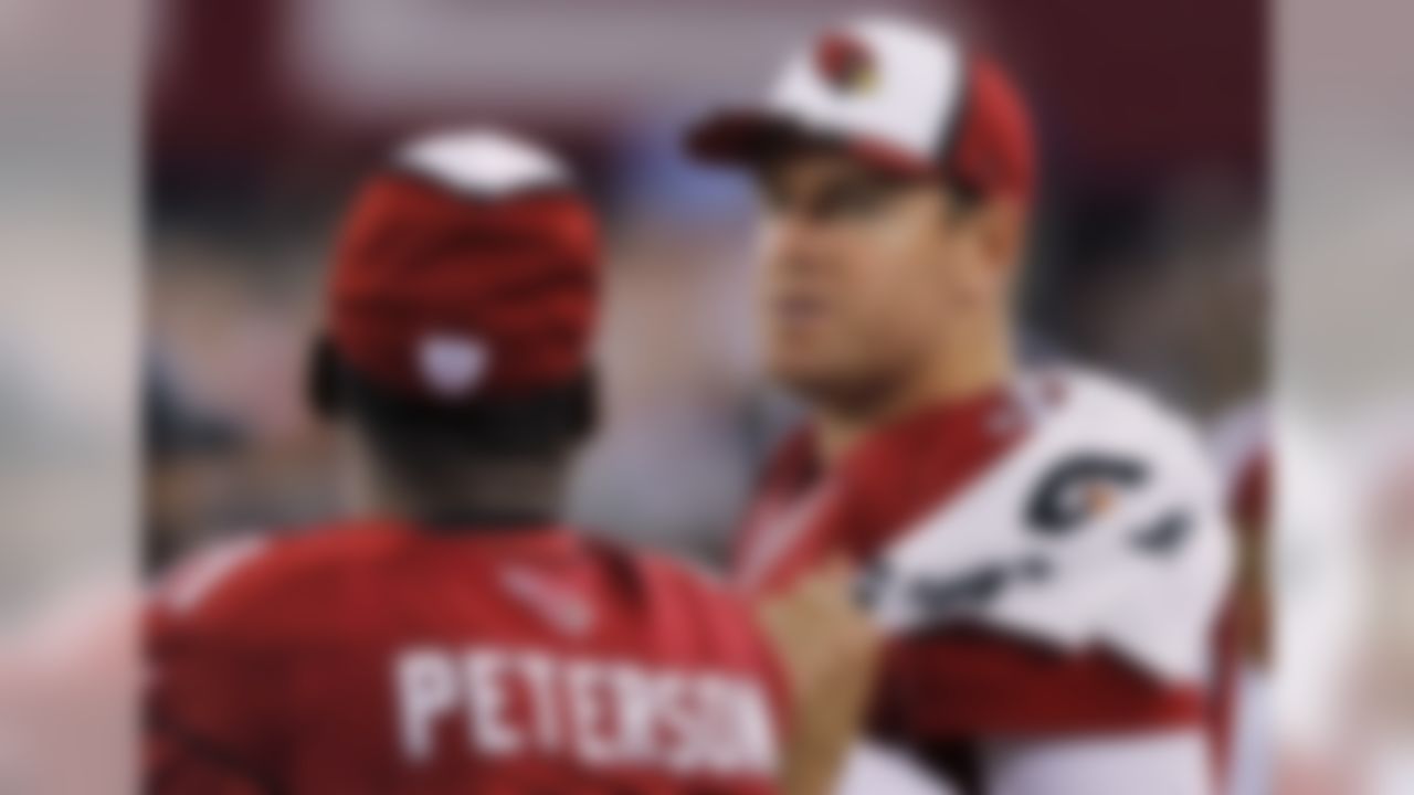 Arizona Cardinals quarterback Carson Palmer talks with teammate Patrick Peterson (21) during the second half of an NFL preseason football game against the Houston Texans, Saturday, Aug. 9, 2014, in Glendale, Ariz. The Cardinals won 32-0. (AP Photo/Rick Scuteri)