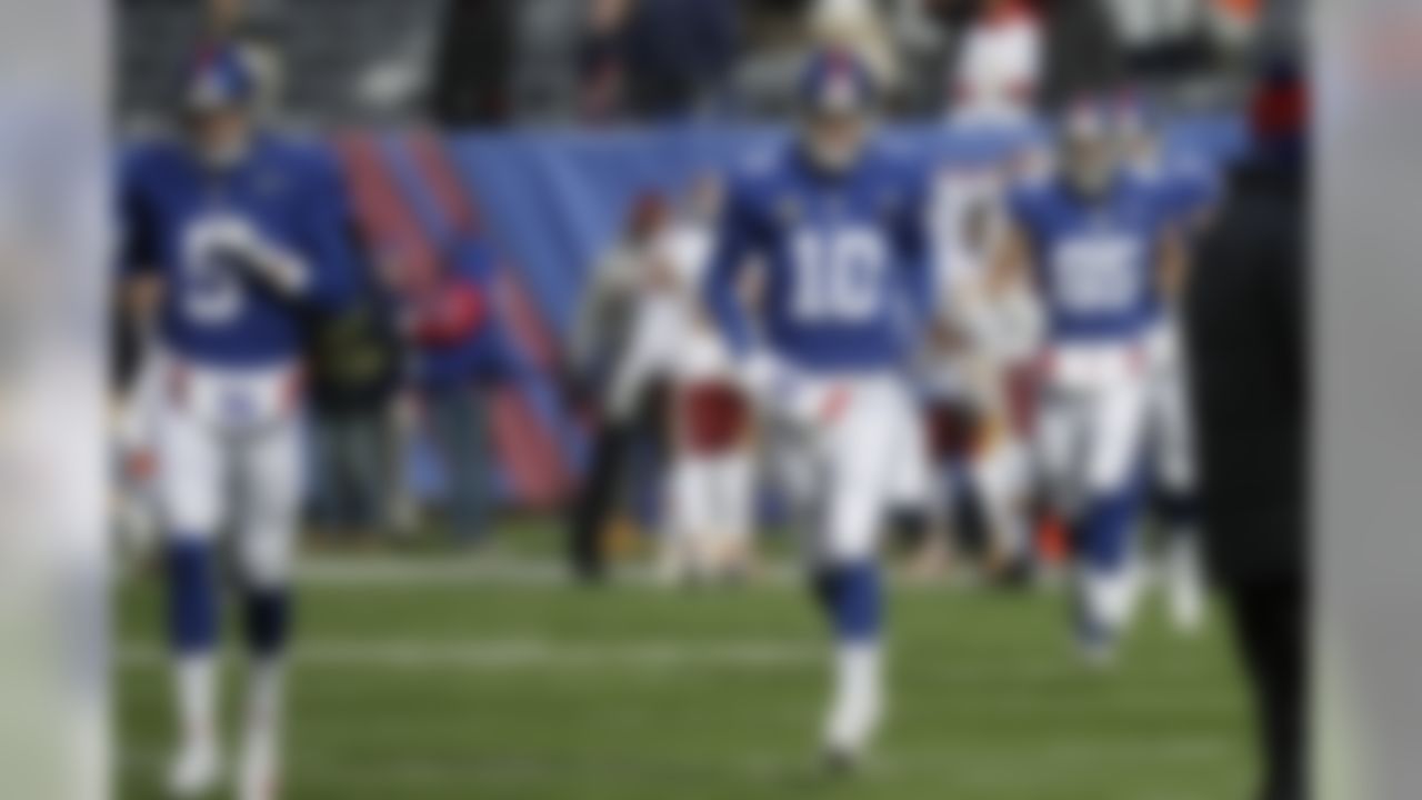 New York Giants quarterback Eli Manning (10) and quarterback Davis Webb (5) run onto the field before an NFL football game against the Washington Redskins Sunday, Dec. 31, 2017, in East Rutherford, N.J. (AP Photo/Mark Lennihan)
