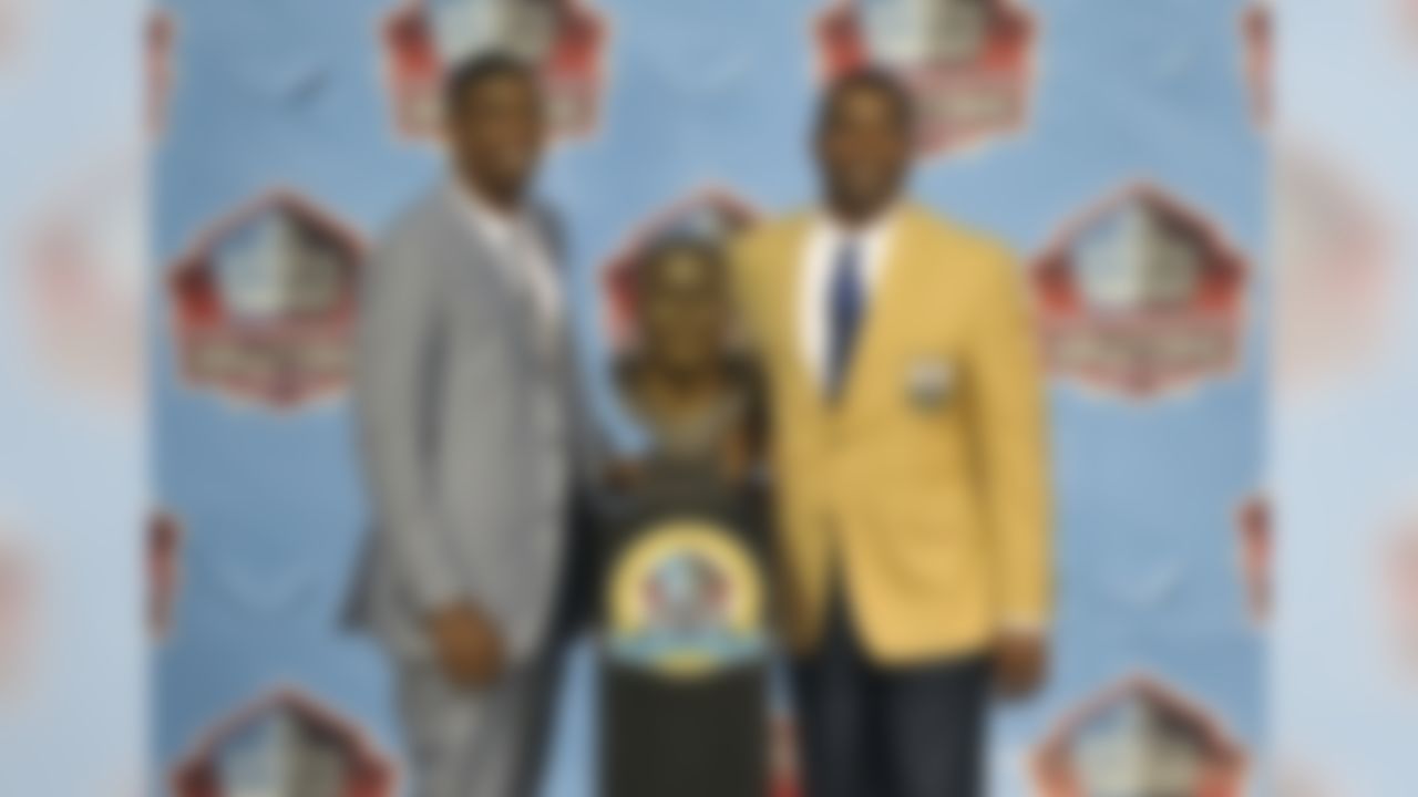 Inductee Cris Carter, right, poses with his presenter, his son Duron Robinson, and a bust of himself during the induction ceremony at the Pro Football Hall of Fame Saturday, Aug. 3, 2013, in Canton, Ohio. (AP Photo/David Richard)
