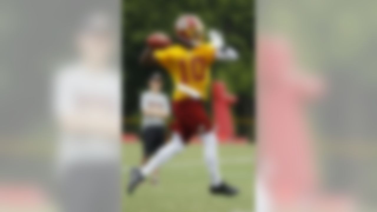 Washington Redskins quarterback Robert Griffin III (10) throws on the run during NFL football training camp at Redskins Park, Friday, July 27, 2012, in Ashburn, Va. (AP Photo/Carolyn Kaster)