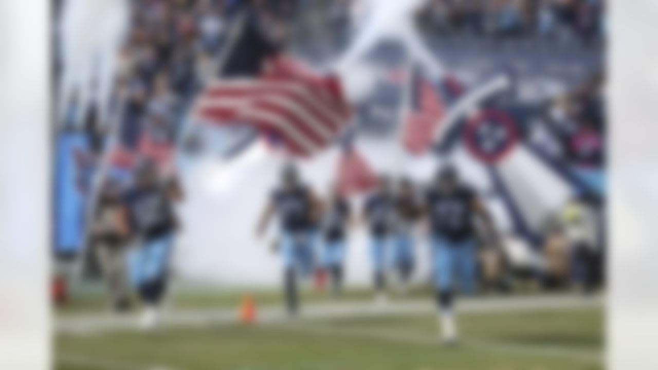 Tennessee Titans players run on the field with American flags prior to an NFL football game against the New Orleans Saints, Sunday, Nov. 14, 2021, in Nashville, Tenn. The Titans won 23-21.