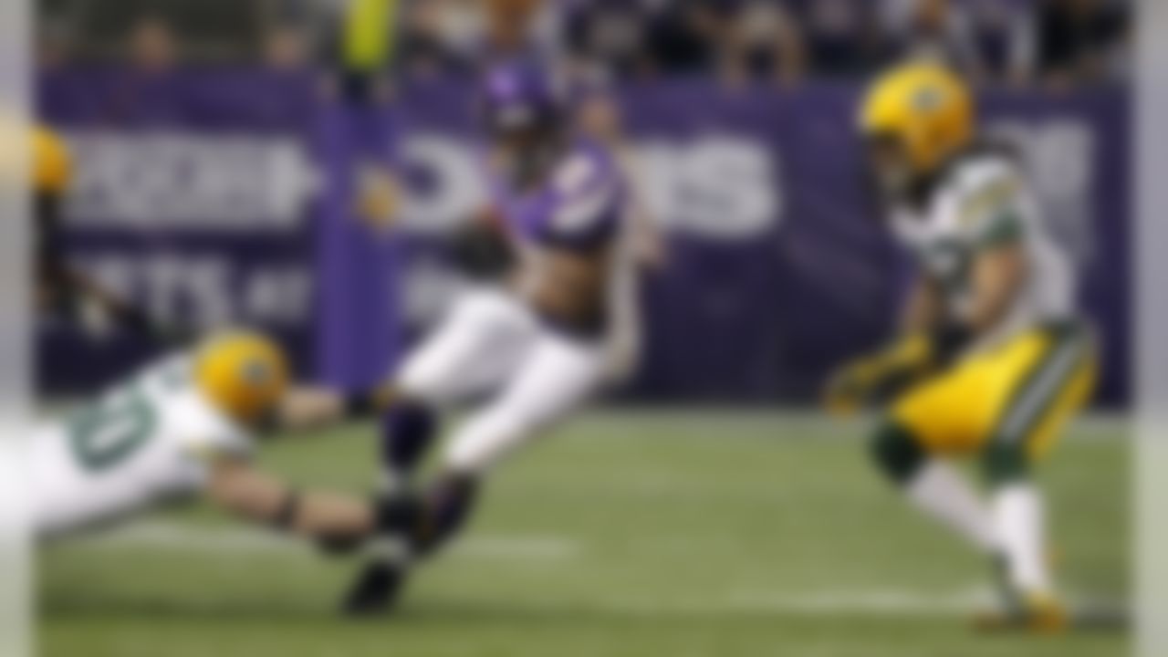 Minnesota Vikings running back Adrian Peterson, center, runs from Green Bay Packers defenders A.J. Hawk, left, and Morgan Burnett, right, during the first half of an NFL football game Sunday, Dec. 30, 2012, in Minneapolis. (AP Photo/Genevieve Ross)