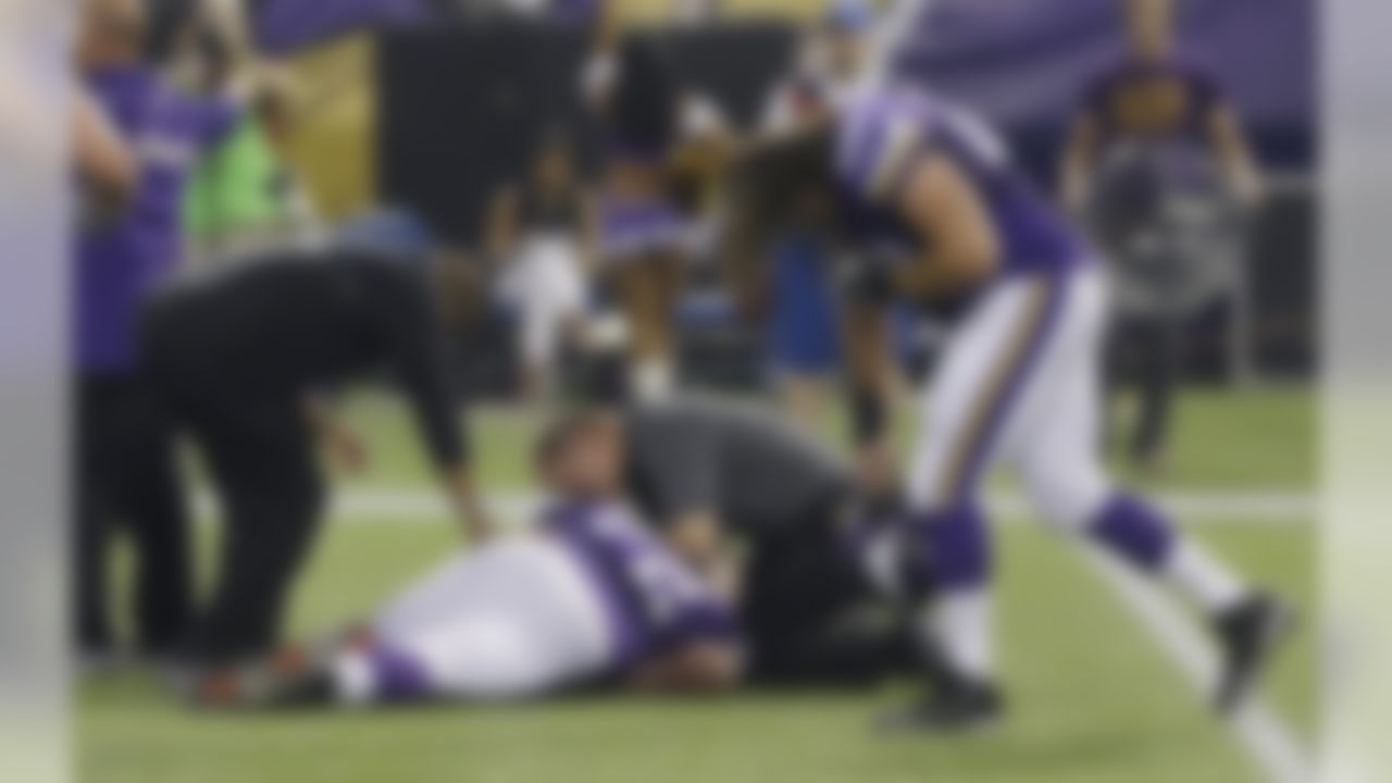 Minnesota Vikings offensive guard Jeff Baca, right, reacts as trainers assist injured Minnesota Vikings guard Seth Olsen, center, during the first half of an NFL preseason football game against the Tennessee Titans Thursday, Aug. 29, 2013, in Minneapolis. (AP Photo/Jim Mone)