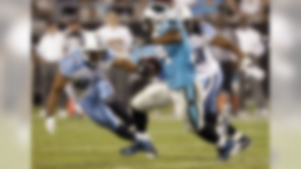 Carolina Panthers' DeAngelo Williams, center, runs as he is chased by Tennessee Titans' Chris Hope, left, and Michael Griffin, right, in the first quarter of a preseason NFL football game in Charlotte, N.C., Saturday, Aug. 28, 2010. (AP Photo/Chuck Burton)