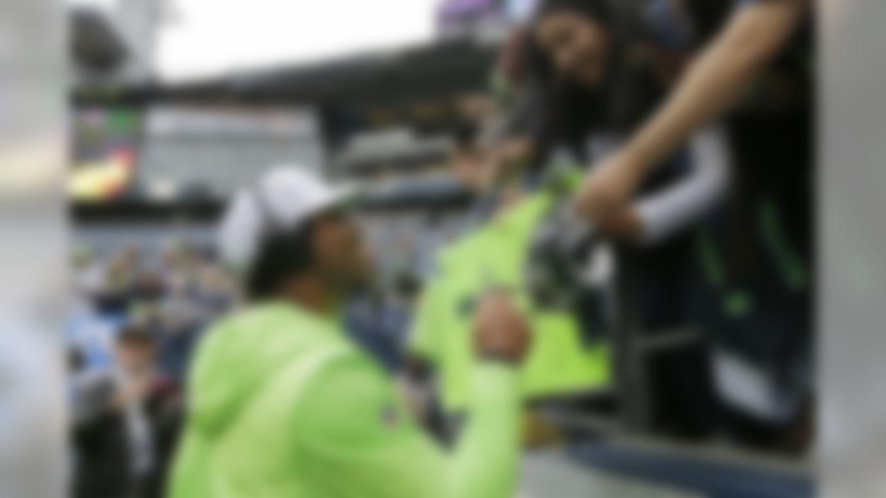 Seattle Seahawks quarterback Russell Wilson  gives autographs before an NFL football game against the Cincinnati Bengals, Sunday, Sept. 8, 2019, in Seattle. (AP Photo/John Froschauer)