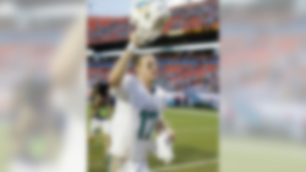 Miami Dolphins quarterback Ryan Tannehill holds up his helmet to fans as he runs off the field after the Dolphins defeated the Atlanta Falcons 27-23 in an NFL football game, Sunday, Sept. 22, 2013, in Miami Gardens, Fla. (AP Photo/Wilfredo Lee)