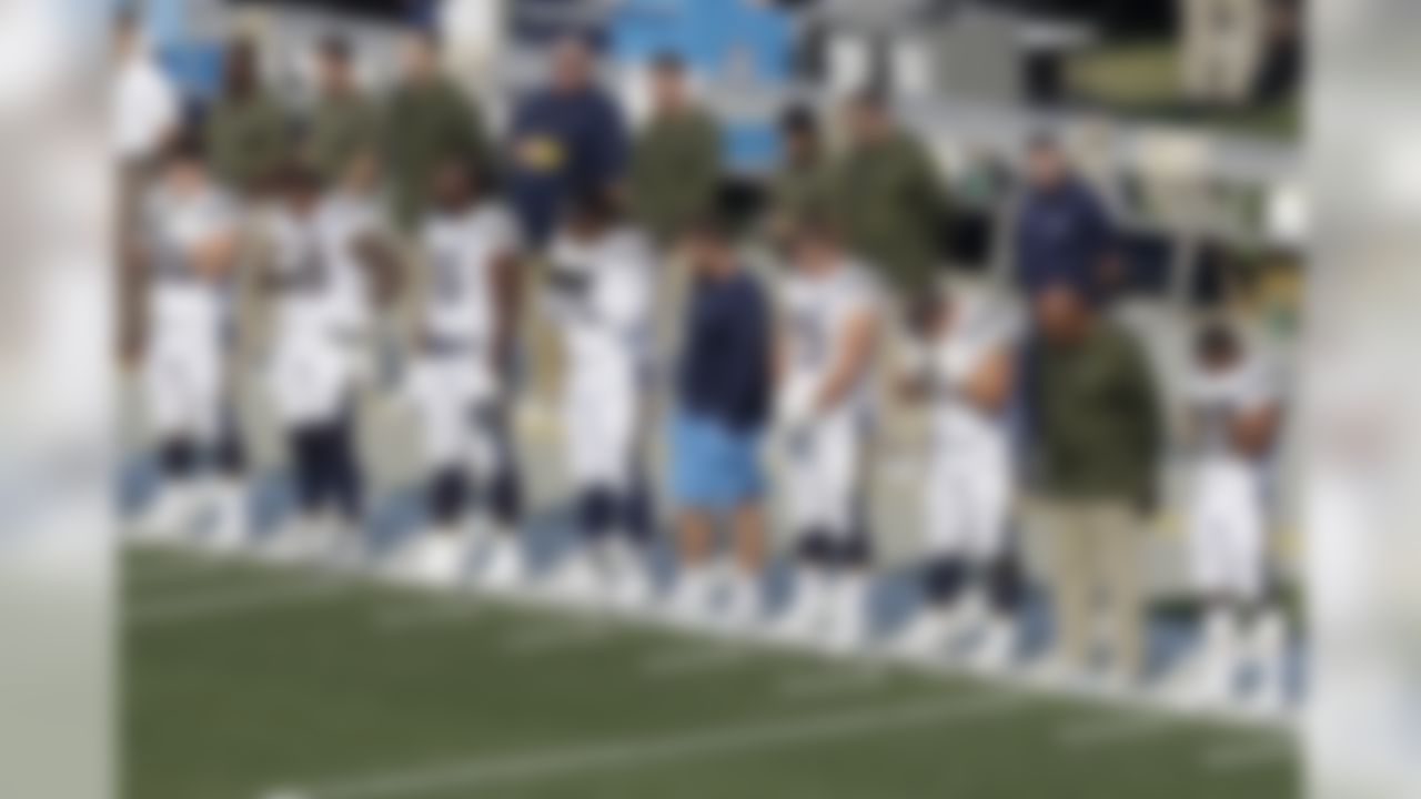 Los Angeles Chargers players and coaches observe a moment of silence for victims of the mass shooting in Southern California and wildfires around the state before an NFL football game between the Oakland Raiders and the Chargers in Oakland, Calif., Sunday, Nov. 11, 2018. (AP Photo/Jeff Chiu)