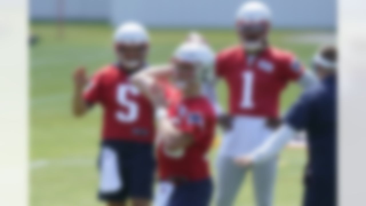 New England Patriots quarterback Mac Jones, center, passes the ball as quarterbacks Brian Hoyer (5) and Cam Newton (1) look on during NFL football practice in Foxborough, Mass., Thursday, May 27, 2021.