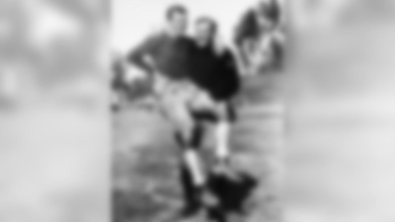 Cal Hubbard, lineman of the Green Bay Packers, carries halfback Roger Grove in his arms in Los Angeles on Jan. 29, 1933. Hubbard weighs 280 pounds, while Grove is only 180 pounds. Grove played with Texas University, while Hubbard starred at Centenary and Geneva. In the summer he is a minor league baseball umpire. (Associated Press)