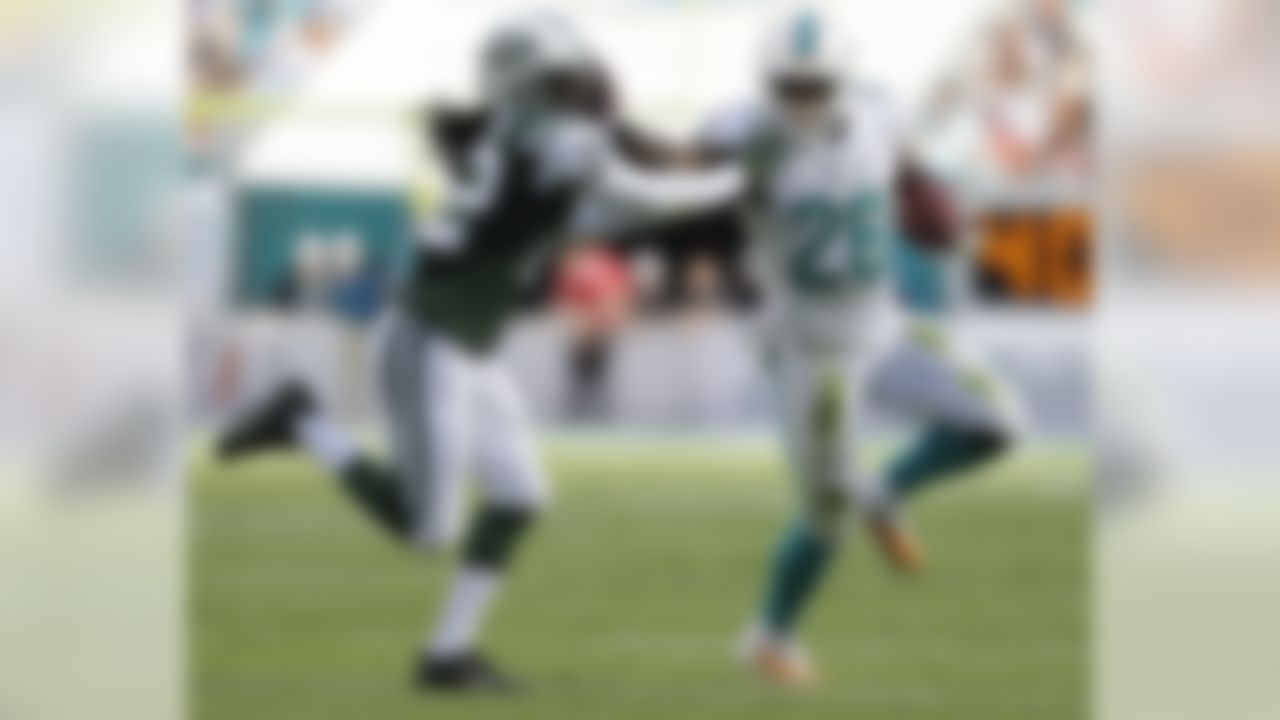 Miami Dolphins running back Lamar Miller (26) carries the ball as New York Jets outside linebacker Quinton Coples (98) attempts to tackle during the first half of an NFL football game, Sunday, Dec. 28, 2014, in Miami Gardens, Fla. (AP Photo/Wilfredo Lee)