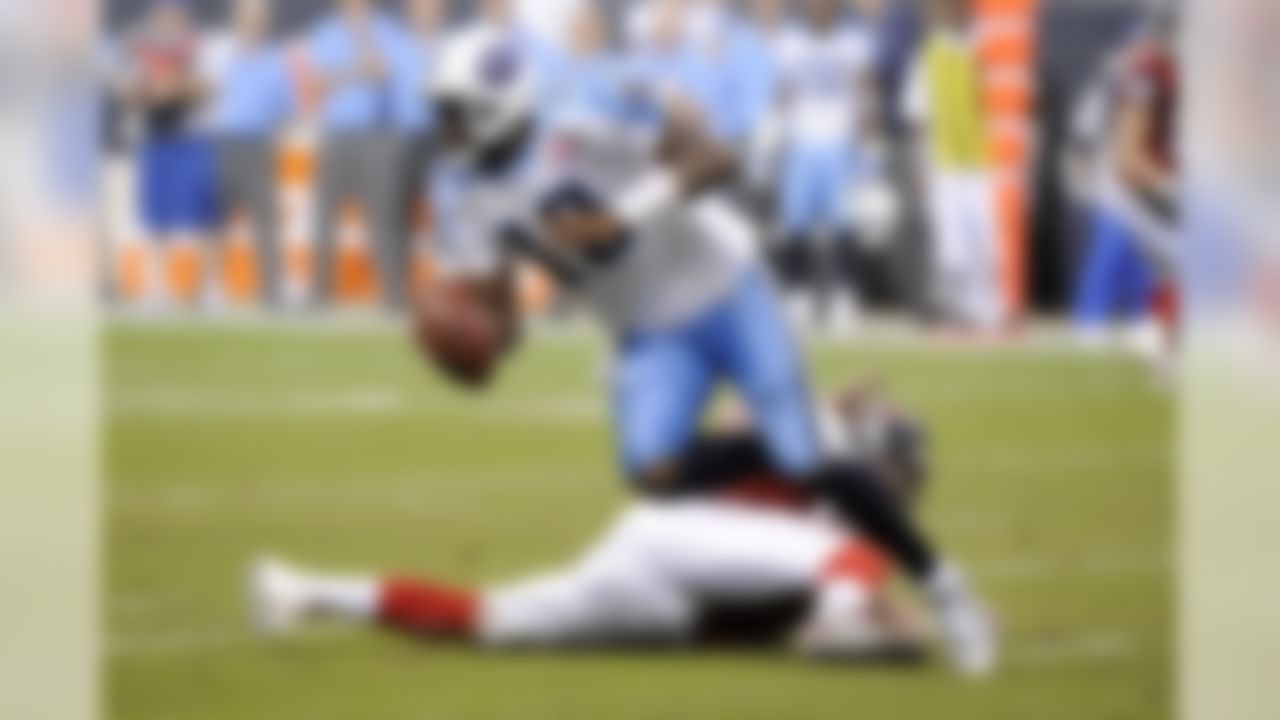 Tennessee Titans quarterback Vince Young (10) scrambles away from Houston Texans' Tim Bulman, bottom, during the fourth quarter of an NFL football game Monday, Nov. 23, 2009 in Houston. The Titans beat the Texans 20-17.  (AP Photo/Dave Einsel)