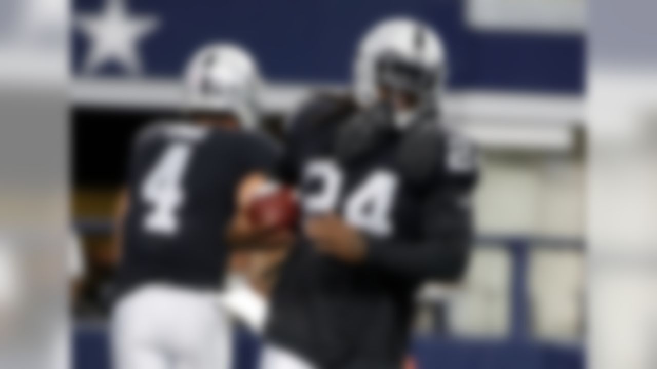 Oakland Raiders running back Marshawn Lynch (24) takes a hand off from quarterback Derek Carr (4) during warm ups before a preseason NFL football game against the Dallas Cowboys on Saturday, Aug. 26, 2017, in Arlington, Texas. (AP Photo/Michael Ainsworth)