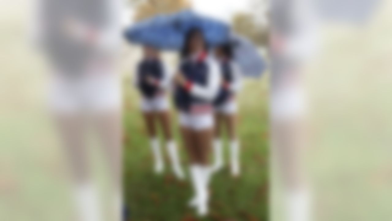 New England Patriots cheerleaders stand underneath their umbrellas as British fans of Tampa Bay Buccaneers and New England Patriots gathered to play a game of touch football at Richmond Park in London, Saturday, Oct. 24, 2009. Tampa Bay Buccaneers are to play New England Patriots in a NFL match on Sunday at Wembley Stadium in London. (AP Photo/Sang Tan)