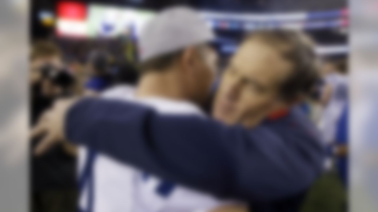 New England Patriots head coach Bill Belichick hugs Indianapolis Colts and former Patriots kicker Adam Vinatieri, left, after an AFC divisional NFL playoff football game in Foxborough, Mass., Saturday, Jan. 11, 2014. The Patriots defeated the Colts 43-22 to advance the AFC Championship game. (AP Photo/Stephan Savoia)