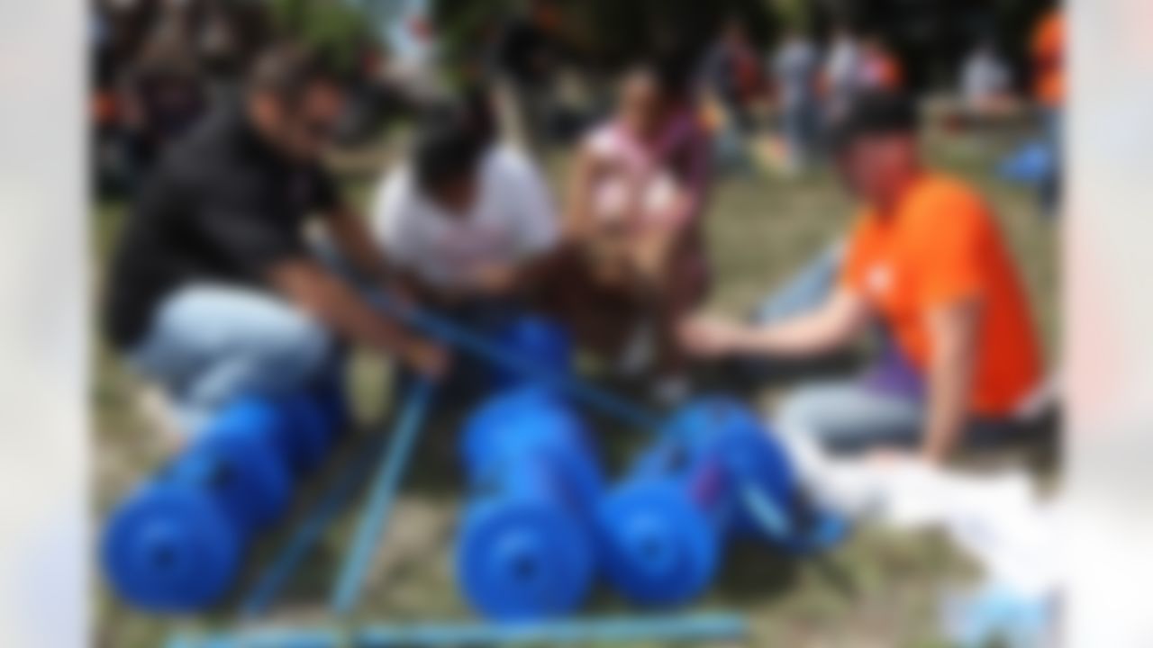 Mike Furrey, David Rock and Claudia Logan help put together the tic-tac-toe board. (Photo by Tom Copeland/Home Depot)