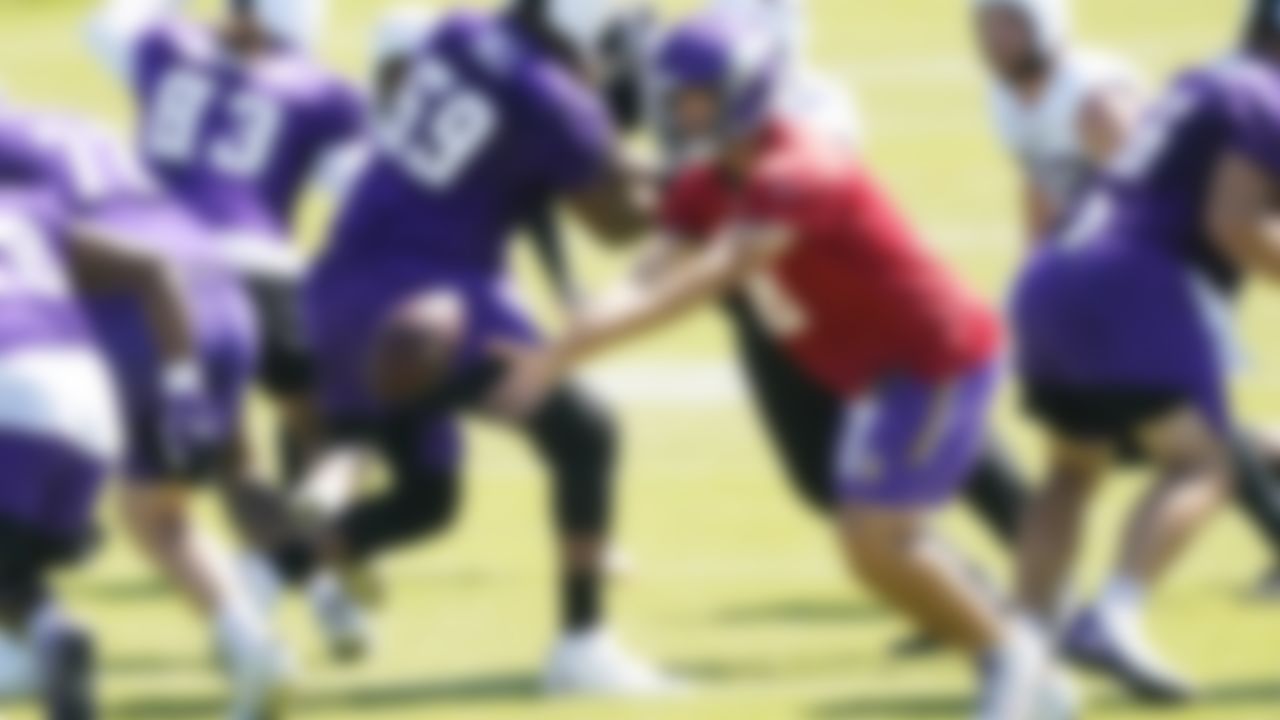 Minnesota Vikings quarterback Kirk Cousins (8) hands off the ball during NFL football minicamp practice Wednesday, June 16, 2021, in Eagan, Minn.