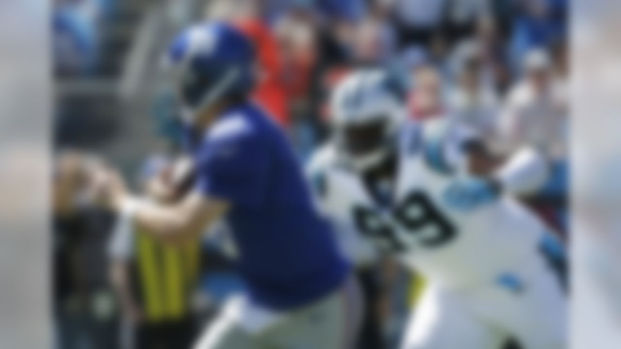 New York Giants quarterback Eli Manning (10) scrambles past Carolina Panthers defensive tackle Kawann Short (99) during the first half of an NFL football game in Charlotte, N.C., Sunday, Sept. 22, 2013. (AP Photo/Chuck Burton)