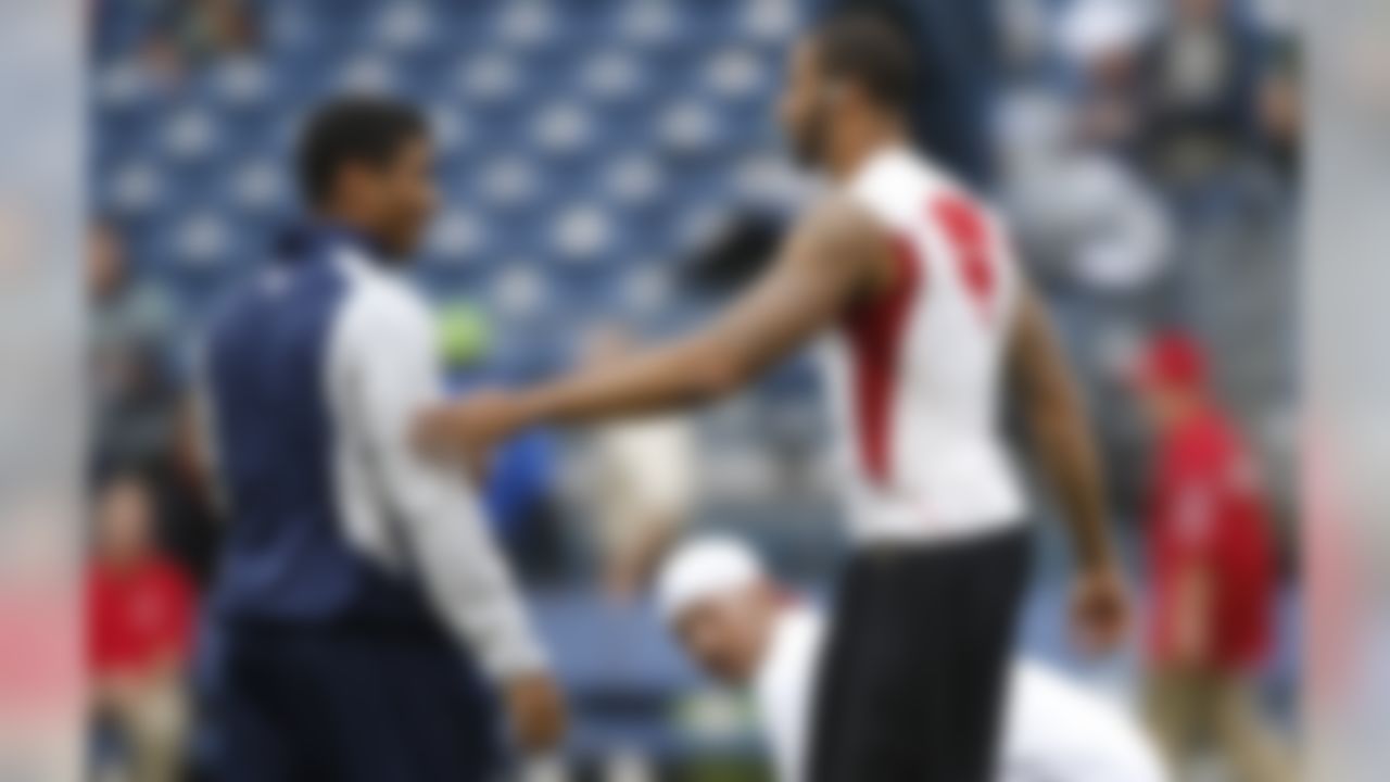 Seattle Seahawks quarterback Russell Wilson, left, greets San Francisco 49ers quarterback Colin Kaepernick, right, on the field prior to an NFL football game, Sunday, Sept. 15, 2013, in Seattle. (AP Photo/John Froschauer)