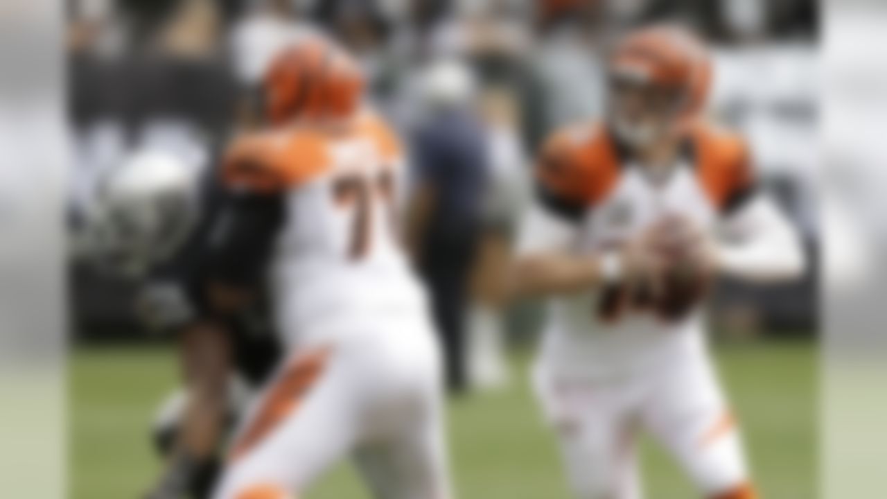 Cincinnati Bengals quarterback Andy Dalton (14) rolls out to pass as tackle Andre Smith (71) blocks Oakland Raiders outside linebacker Khalil Mack (52) during the first half of an NFL football game in Oakland, Calif., Sunday, Sept. 13, 2015. (AP Photo/Ben Margot)