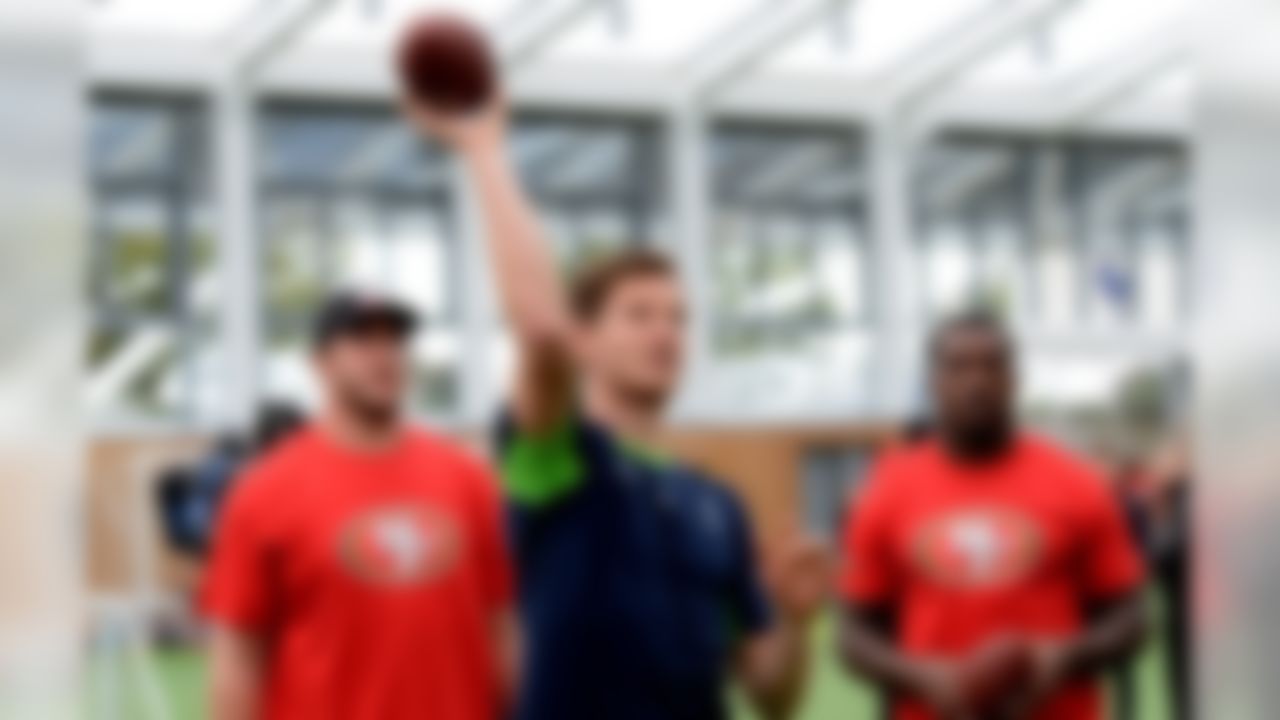 Tottenham Hotspur's defender Jan Vertonghen tosses an American football in front of San Francisco 49ers Joe Staley (left) and Patrick Willis during an event where players from the 49ers and Hotspurs [English Premier League] interacted with local community school children at the Spurs practice facility. (Dave Shopland/NFL)