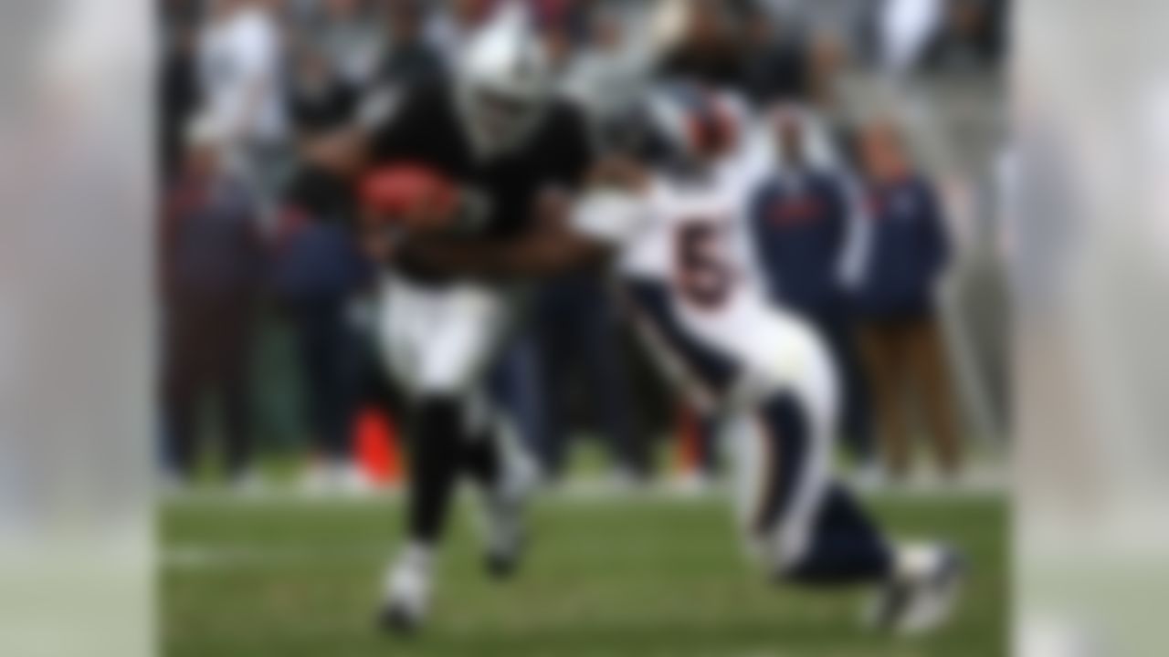 OAKLAND, CA - DECEMBER 2:  JaMarcus Russell #2 of the Oakland Raiders runs with the ball as D. J. Williams #55 of the Denver Broncos makes the tackle during an NFL game at McAfee Coliseum December 2, 2007 in Oakland, California.  (Photo by Jed Jacobsohn/Getty Images)