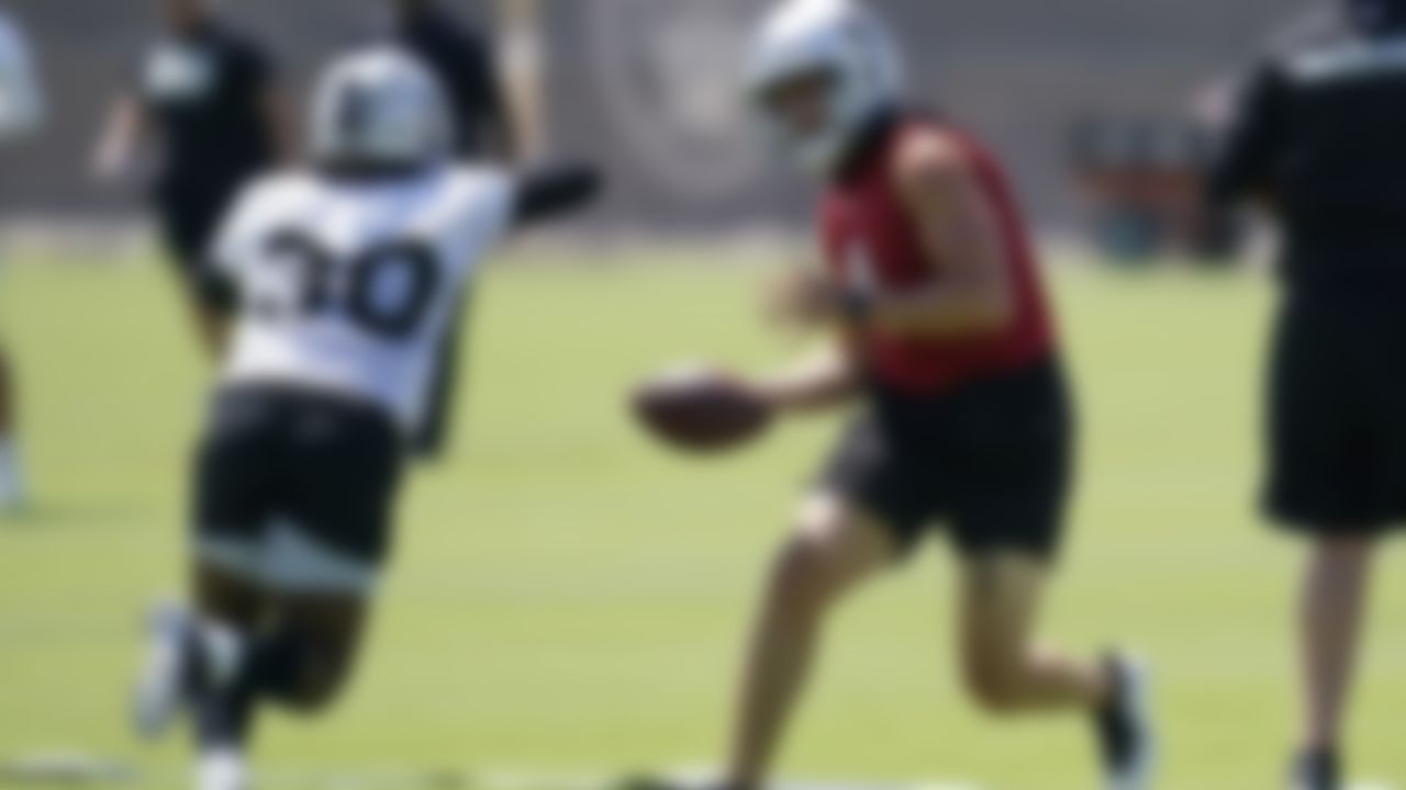Las Vegas Raiders quarterback Derek Carr (4) looks to hand off to running back Jalen Richard (30) during NFL football practice Wednesday, June 2, 2021, in Henderson, Nev.