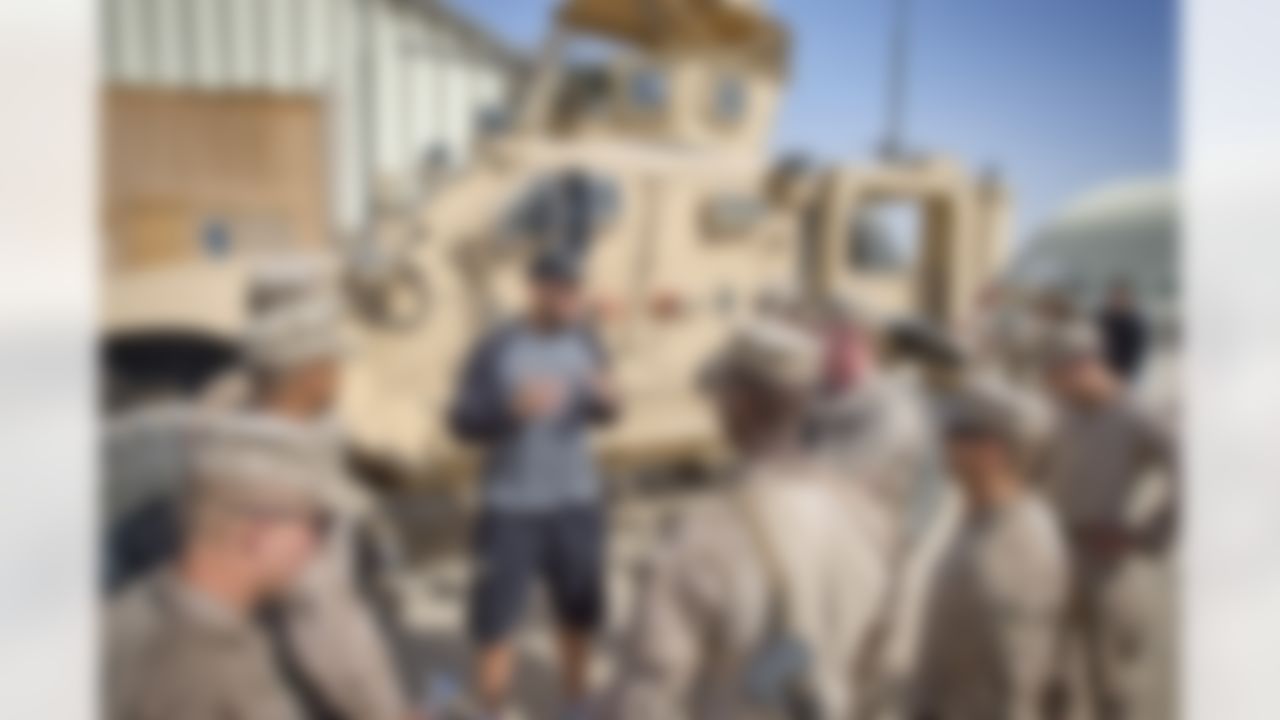Continuing a time honored USO/NFL tradition, Brandon Fields of the Miami Dolphins, Pierre Garcon of the Washington Redskins and Jimmy Graham of the New Orleans Saints pose for a group of troops stationed in the Middle East on March 4, 2014. This is the trio's first USO/NFL tour. (USO Photo by Dave Gatley)