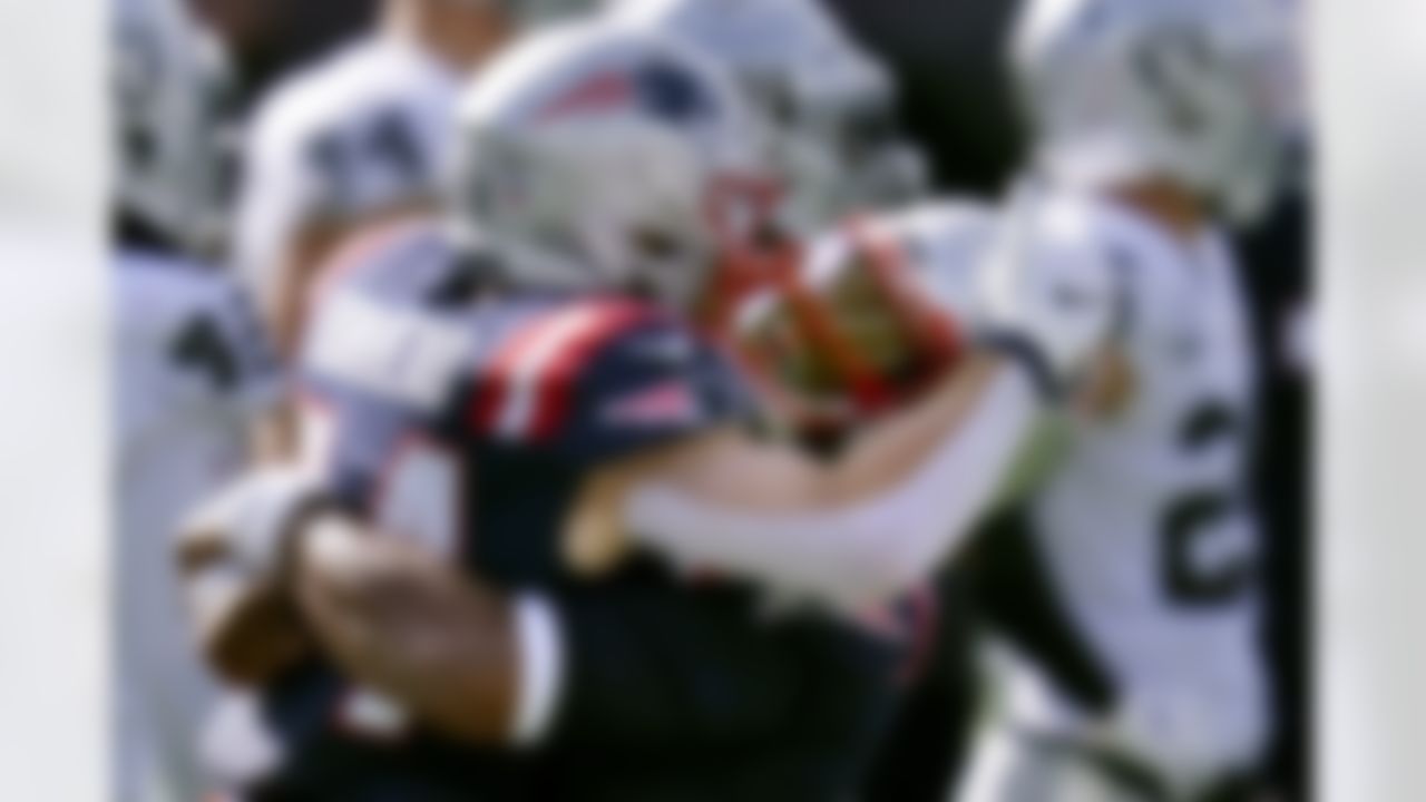 New England Patriots quarterback Cam Newton, right, gives running back Rex Burkhead a lift after Burkhead's touchdown in the second half against the Las Vegas Raiders. Burkhead ended up with three scores in the Patriots' victory.