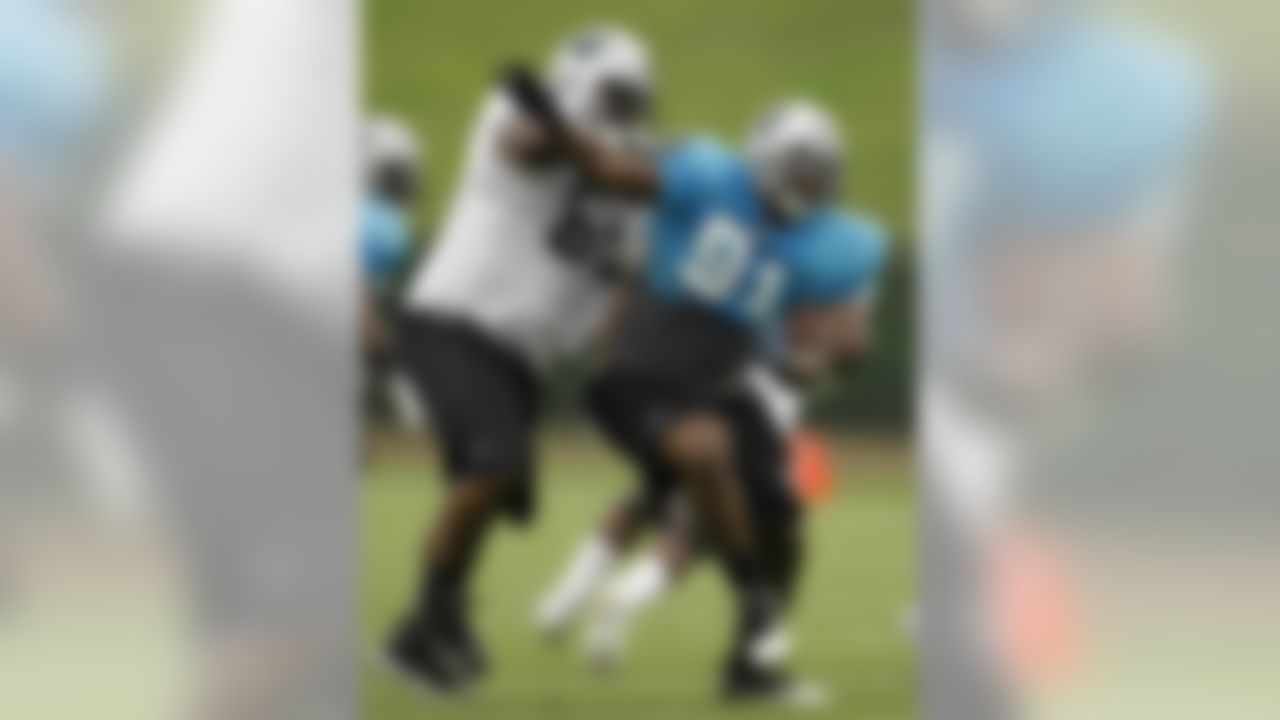 Carolina Panthers' Everette Brown (91) runs past Garry Williams (65) during practice at the NFL football team's training camp in Spartanburg, S.C., Saturday, July 31, 2010. (AP Photo/Chuck Burton)