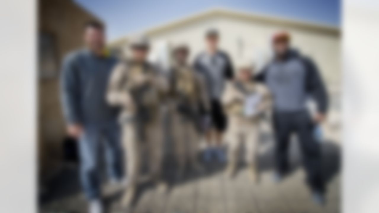 Continuing a time honored USO/NFL tradition, Brandon Fields of the Miami Dolphins, Pierre Garcon of the Washington Redskins and Jimmy Graham of the New Orleans Saints pose for a group of troops stationed in the Middle East on March 4, 2014. This is the trio's first USO/NFL tour. (USO Photo by Dave Gatley)