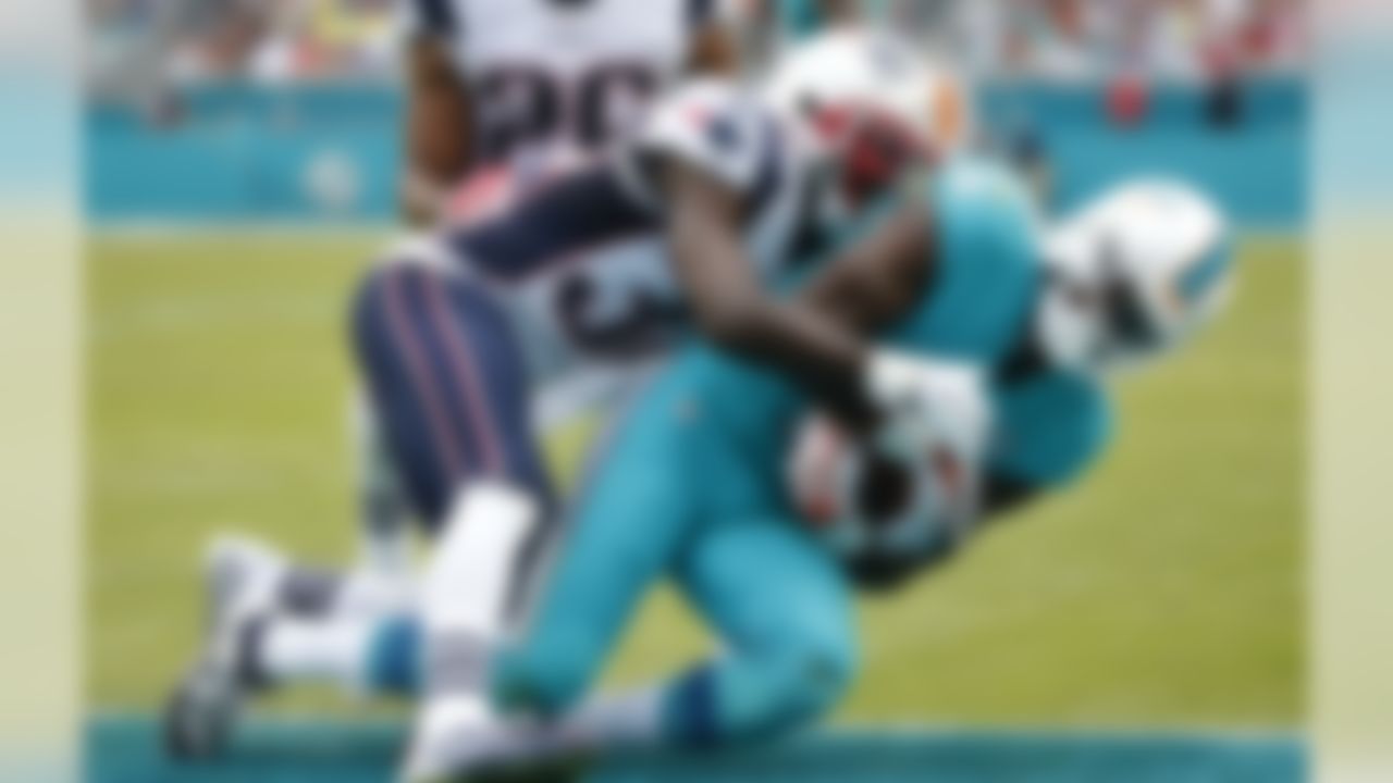 Miami Dolphins wide receiver DeVante Parker (11) scores a touchdown as New England Patriots free safety Devin McCourty (32) defends during the first half of an NFL football game, Sunday, Jan. 3, 2016 in Miami Gardens, Fla. (AP Photo/Wilfredo Lee)