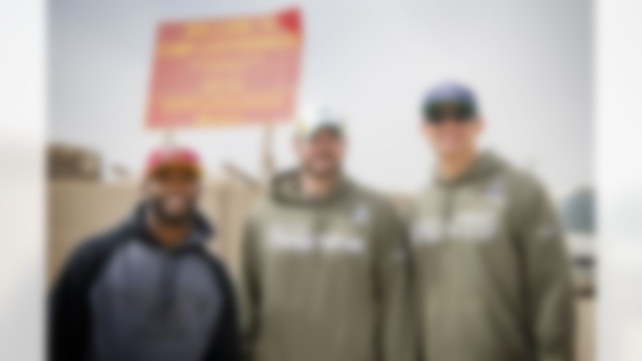 Pierre Garcon of the Washington Redskins, Brandon Fields of the Miami Dolphins and Jimmy Graham of the New Orleans Saints take time out of their six-day USO/NFL tour to pose for a group photo at Camp Leatherneck in Afghanistan on March 5, 2014. This trip marks the trio's first USO experience. (USO Photo by Dave Gatley)