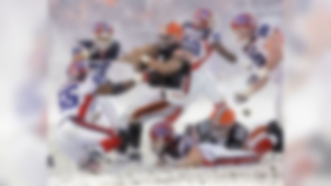 Cleveland Browns running back Jamal Lewis, center, runs through the snow and Buffalo Bills defenders Angelo Crowell (55), Keith Ellison (56), Chris Kelsay (90) and Kyle Williams (95) for four yards in the fourth quarter of an NFL football game Sunday, Dec. 16, 2007, in Cleveland. Lewis gained 163 yards on 33 attempts in the Browns' 8-0 win. (AP Photo/Tony Dejak)