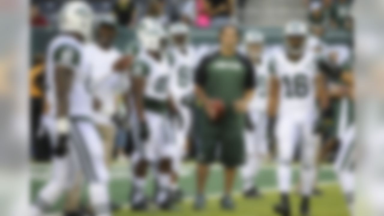 New York Jets quarterback Mark Sanchez, center, holds a football as teammates warm up before a preseason NFL football game against the Philadelphia Eagles, Thursday, Aug. 29, 2013, in East Rutherford, N.J. (AP Photo/Bill Kostroun)