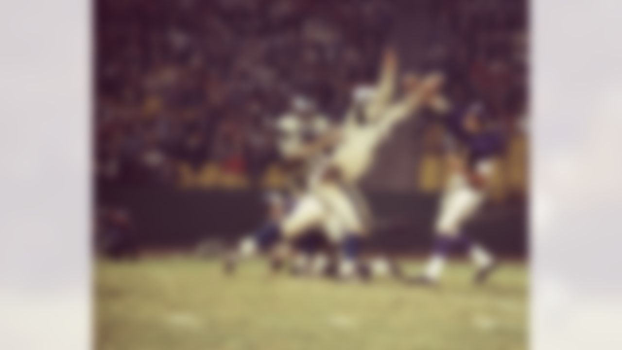 Hall of Fame defensive tackle Merlin Olsen (74) of the Los Angeles Rams pressures Vikings quarterback Joe Kapp (11) during a 21 to 6 Rams win over the Minnesota Vikings on Nov. 20, 1966 at the Los Angeles Memorial Coliseum in Los Angeles. (National Football League)
