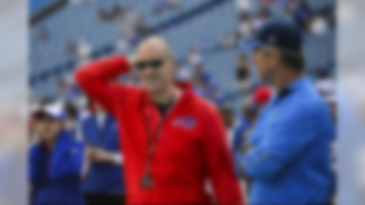 Former Buffalo Bills quarterback Jim Kelly, left, smiles as he talks to San Diego Chargers offensive coordinator Frank Reich, right, as the Buffalo Bills and the San Diego Chargers warm up for a NFL football game Sunday, Sept. 21, 2014, in Orchard Park, N.Y. (AP Photo/Gary Wiepert)