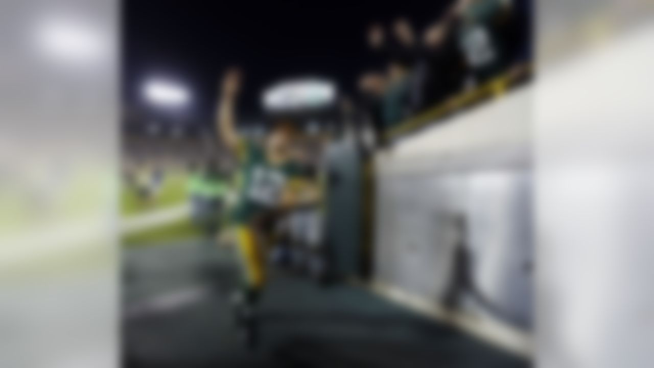 Green Bay Packers' Aaron Rodgers tosses his wristbands to fans as he runs into the locker room after the second half of an NFL football game against the Chicago Bears Thursday, Sept. 13, 2012, in Green Bay, Wis. The Packers won 23-10. (AP Photo/Mike Roemer)